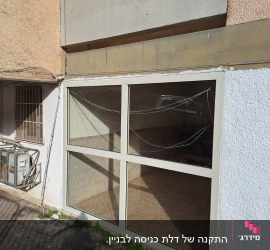 חלון אלומיניום עם מסגרת לבנה על קיר חיצוני
